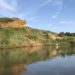 Canoe on Kanopolis Lake, Kansas. Sandstone formation reflected in water.