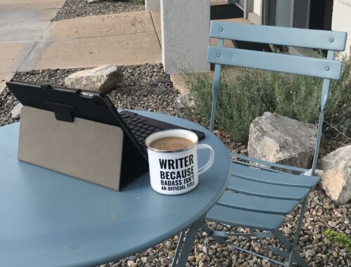 Small table, iPad, and mug that says writer, because badass isn't a job title